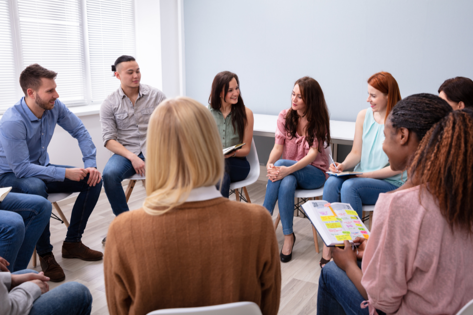 Students sitting in chairs in a circle discussing psychology